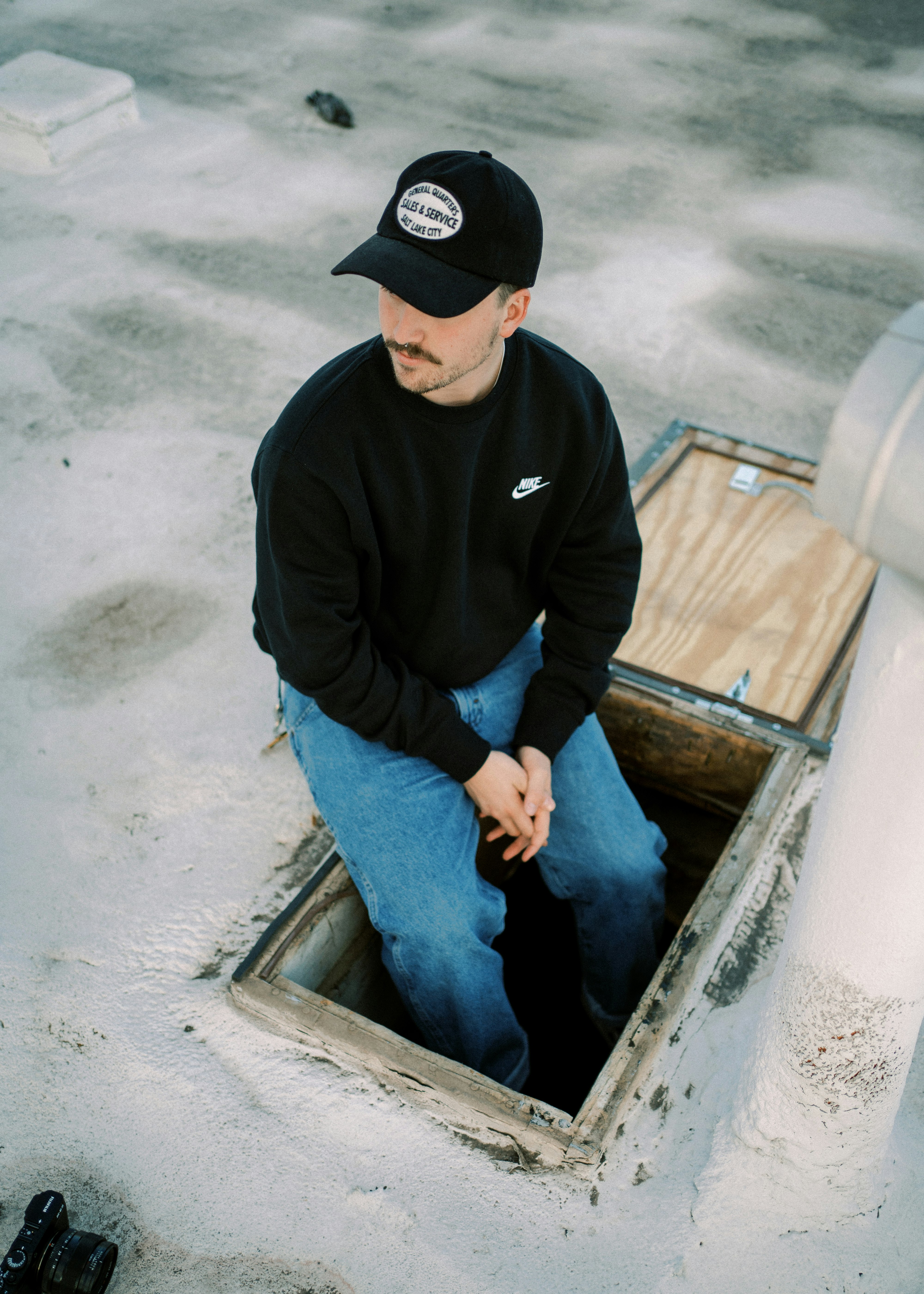 man in black nike jacket and blue denim jeans sitting on boat